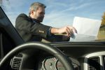 man putting an annoying flier on a windshield