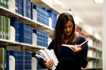 Young woman looking at books in a Library