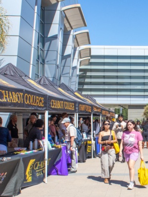 visitors walking past a line of booths